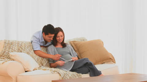 Expecting Parents Enjoying Ultrasound Scan on Couch
