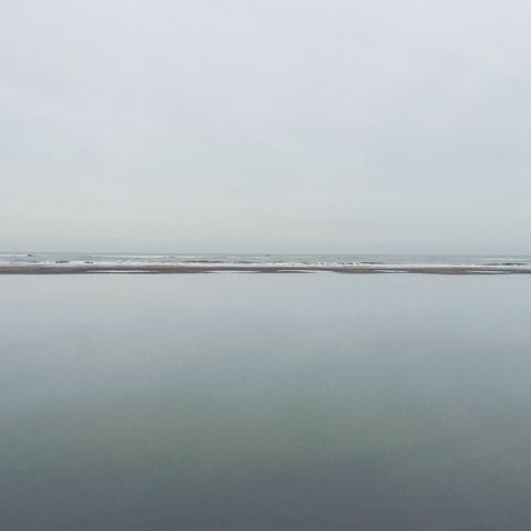 Tranquil overcast beach scene with calm waters
