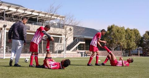 Soccer Players Demonstrating Teamwork and Assistance on Field