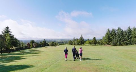 Group of Friends Walking on Golf Course Fairway