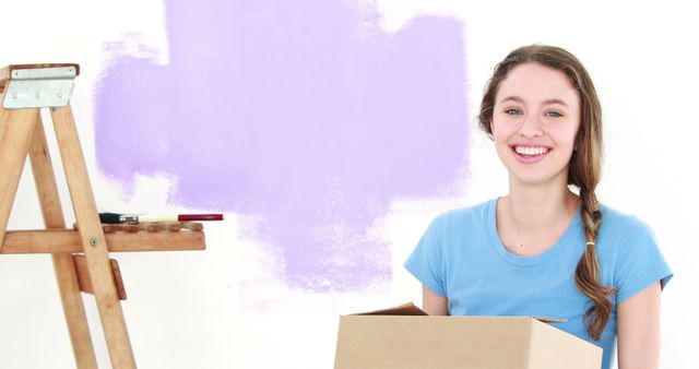 Smiling Young Woman with Moving Box and Painting Background - Download Free Stock Images Pikwizard.com