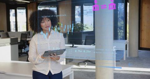 Focused Businesswoman Analyzing Financial Data on Tablet in Modern Office