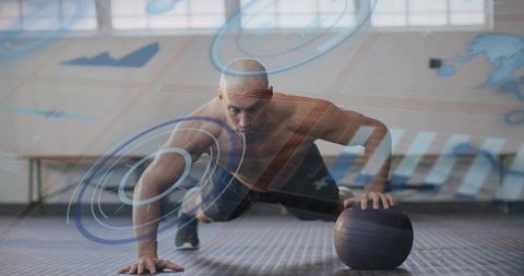 Bald athlete performing one-arm push-up with medicine ball and futuristic hud overlay studio