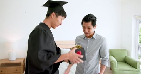 Graduate hugging family member and celebrating achievement at home