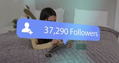Influencer growing followers while browsing tablet on bed with passport and card