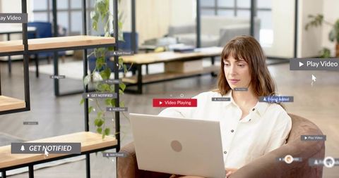 Freelancer woman using laptop in modern coworking lounge with floating notification overlays