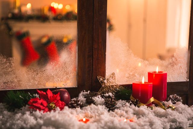 Perfect for holiday-themed promotions, greeting cards, or social media posts. Captures the warmth and coziness of the Christmas season with red candles, poinsettia, and festive decorations on a bed of fake snow. Ideal for creating a festive atmosphere in advertisements or seasonal blog posts.