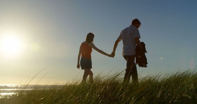 Young couple holding hands and walking on the beach - Download Free Stock Photos Pikwizard.com