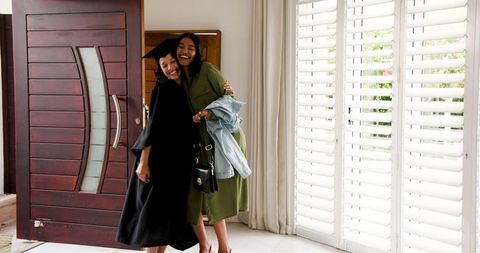 Proud Mother Celebrating Daughter's Graduation at Home Entrance