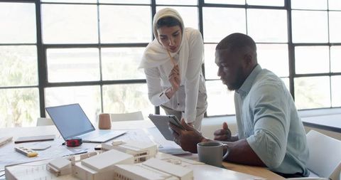 Business colleagues collaborate using technology in office