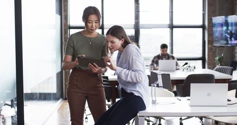 Two Female Colleagues Collaborating with Tablet in Modern Office - Download Free Stock Images Pikwizard.com