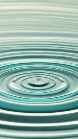 Droplet creating concentric ripples in turquoise water surface vertical slow-motion video