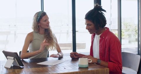 Young Professionals Collaborating at Work with Documents and Tablet