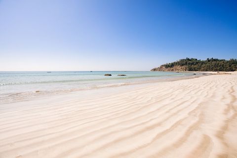Rippling Sand Leading to Turquoise Sea at Sunny Coastal Headland