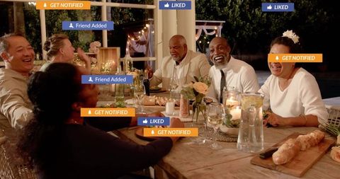 Friends enjoying alfresco dinner party with laughter, candles and social media icons