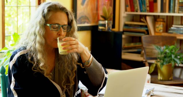 Middle-aged Woman Working from Home Drinking Beverage - Download Free Stock Images Pikwizard.com