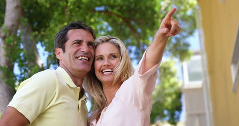 Joyful Couple Enthusiastically Pointing Outdoors on Sunny Day - Download Free Stock Images Pikwizard.com