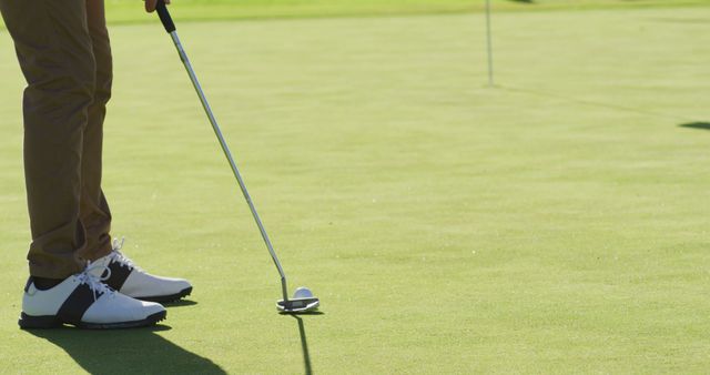 Image of legs of caucasian man playing golf on golf field. sporty, active lifestyle and playing golf concept.