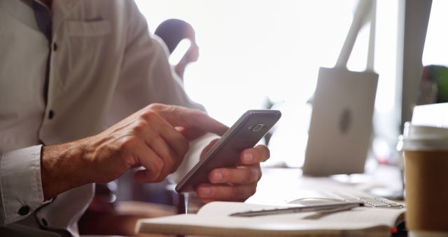 Close up of a male executive using mobile phone at desk in office - Download Free Stock Photos Pikwizard.com