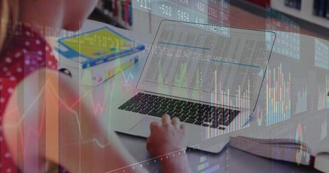 Typing Student at Desk with Laptop and Financial Charts Overlay Showing Data Analysis