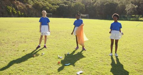 Diverse Group of Young Volunteers Collecting Litter Outdoors