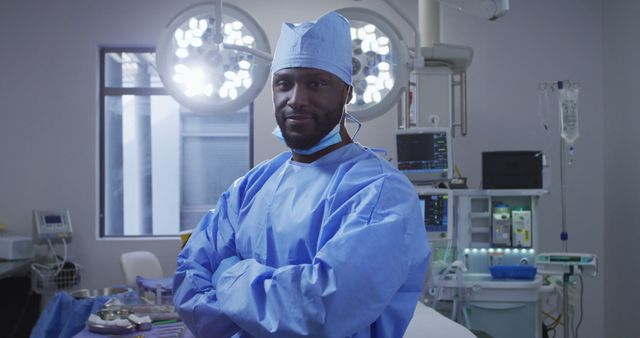 Portrait of african american male surgeon wearing protective clothes standing in operating theatre. medicine, health and healthcare services.