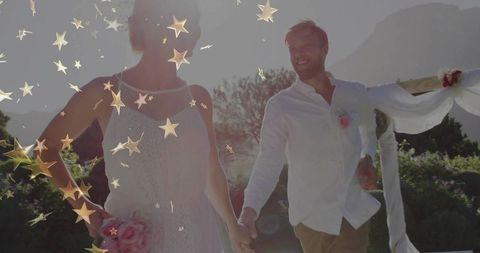 Couple Holding Hands Under Romantic Wedding Arch Outdoors