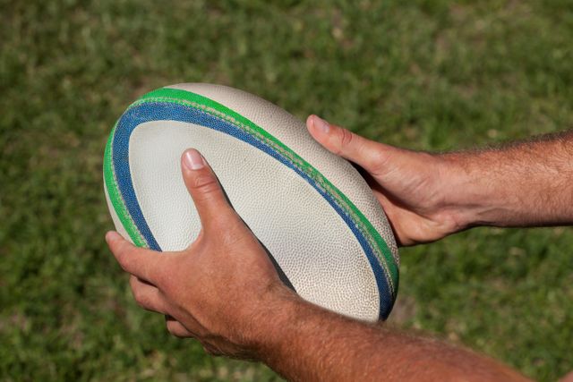 Hands Holding Rugby Ball on Grass Field - Download Free Stock Photos Pikwizard.com