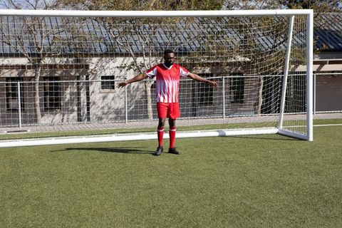 Athlete Practicing Soccer in Red and White Jersey on Turf