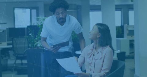 Team Discussion in Casual Office Environment with Tablet and Document