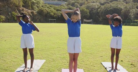 Diverse Girls Exercising Outdoors on Field with Winter Wheat