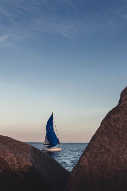 Sailboat with Blue Sails On Open Sea During Sunset - Download Free Stock Photos Pikwizard.com