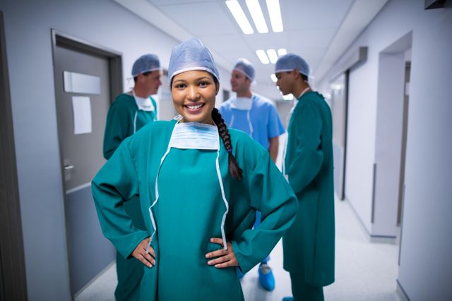 Portrait of female surgeon standing with arms crossed in corridor