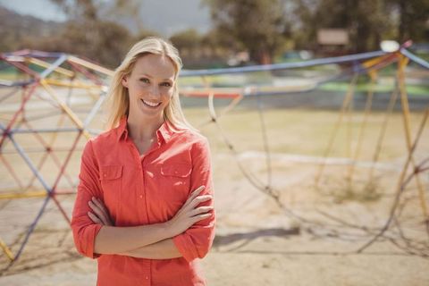 Smiling Woman at Park with Playground Climbing Structures
