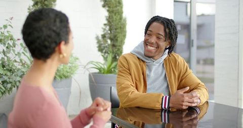 African american man and woman smiling in casual business conversation in bright workspace