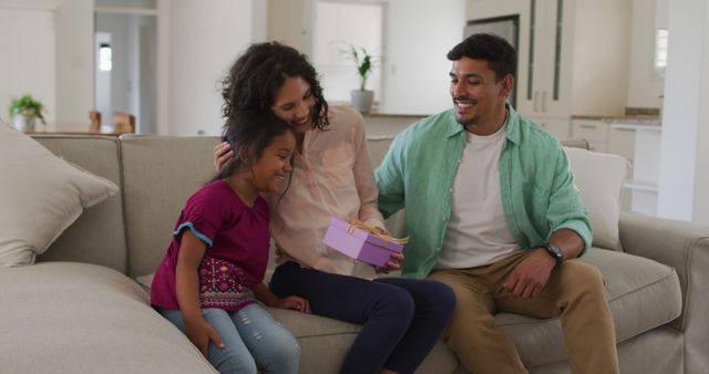 Sweet Family Moments on Couch with Present, Parents and Child Smiling - Download Free Stock Images Pikwizard.com