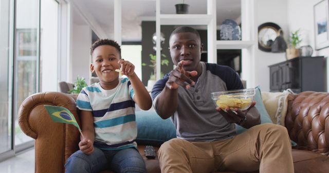 Father and Son Watching Sports Game Cheerfully Sitting on Couch - Download Free Stock Images Pikwizard.com