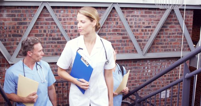 Medical Professionals Walking Down Stairs in Modern Hospital - Download Free Stock Images Pikwizard.com