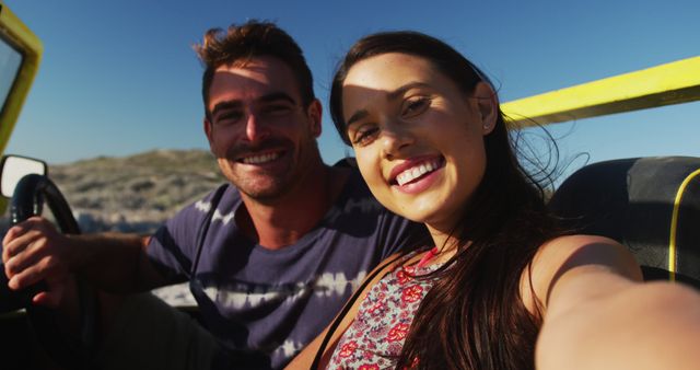 Happy caucasian couple sitting in beach buggy by the sea using smartphone taking selfies - Download Free Stock Photos Pikwizard.com