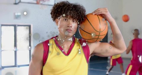Athletic Male Basketball Player Holding Ball in Gym