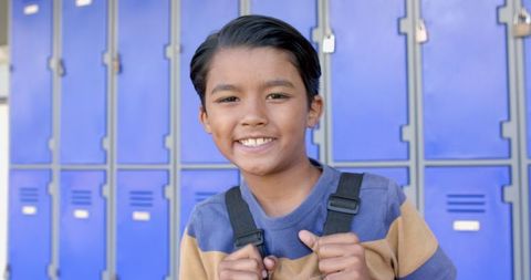 Confident Biracial Boy Smiling in Front of School Lockers