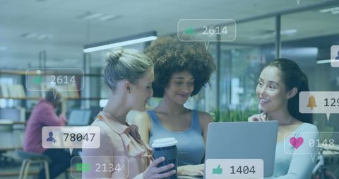 Women Collaborating on Social Media Strategy in Modern Office