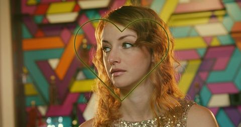 Caucasian Woman with Neon Heart Lighting on Smartphone