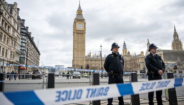 Uniformed officers guarding cordon at westminster with big ben and parliament