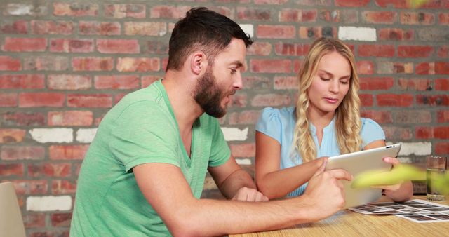 Man and Woman Reviewing Photos on Tablet in Cafe - Download Free Stock Images Pikwizard.com