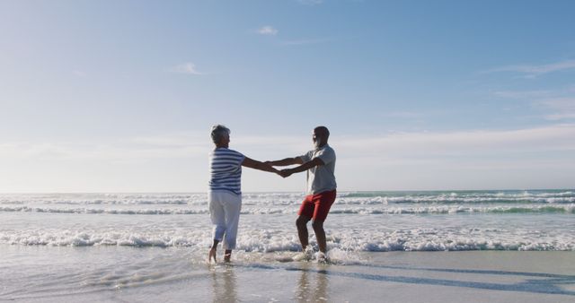 Senior african american couple dancing at the beach. healthy outdoor leisure time by the sea.