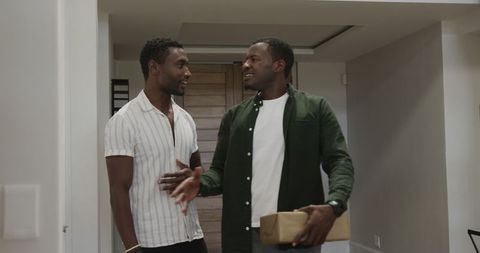 Friends at home holding gift and greeting