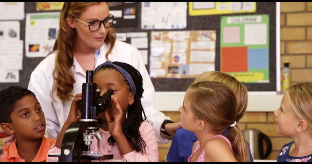 Teacher Guiding Diverse Group of Students Using Microscope in Classroom - Download Free Stock Images Pikwizard.com