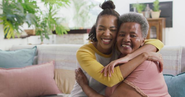 Portrait of african american mother and daughter smiling while hugging each other at home. motherhood and love concept