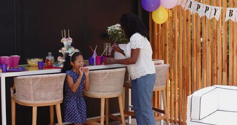 Mother and Daughter Preparing Colorful Party Table at Home